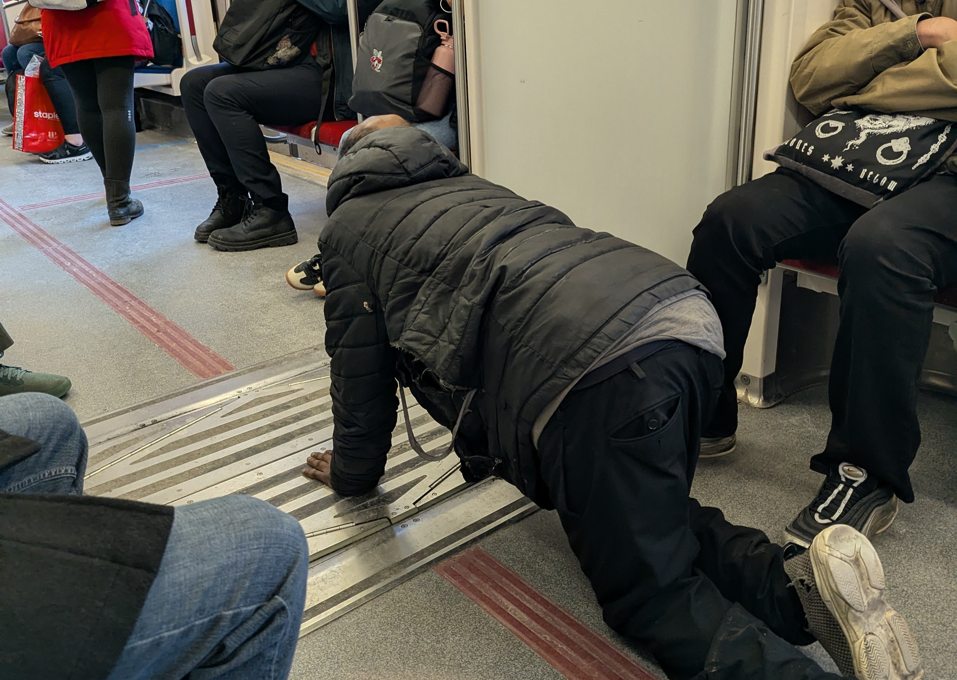 man crawling on the subway, begging for money.