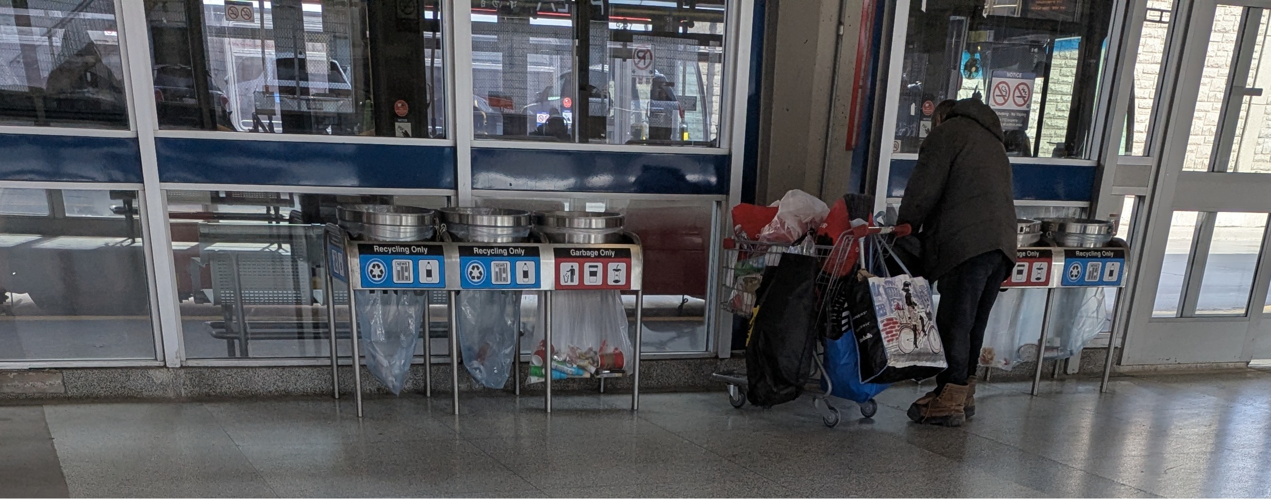 Man searching inside of recycling bins.